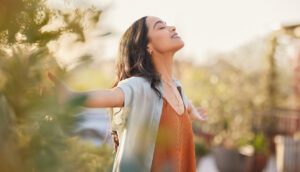 Woman enjoying nature with outstretched arms.
